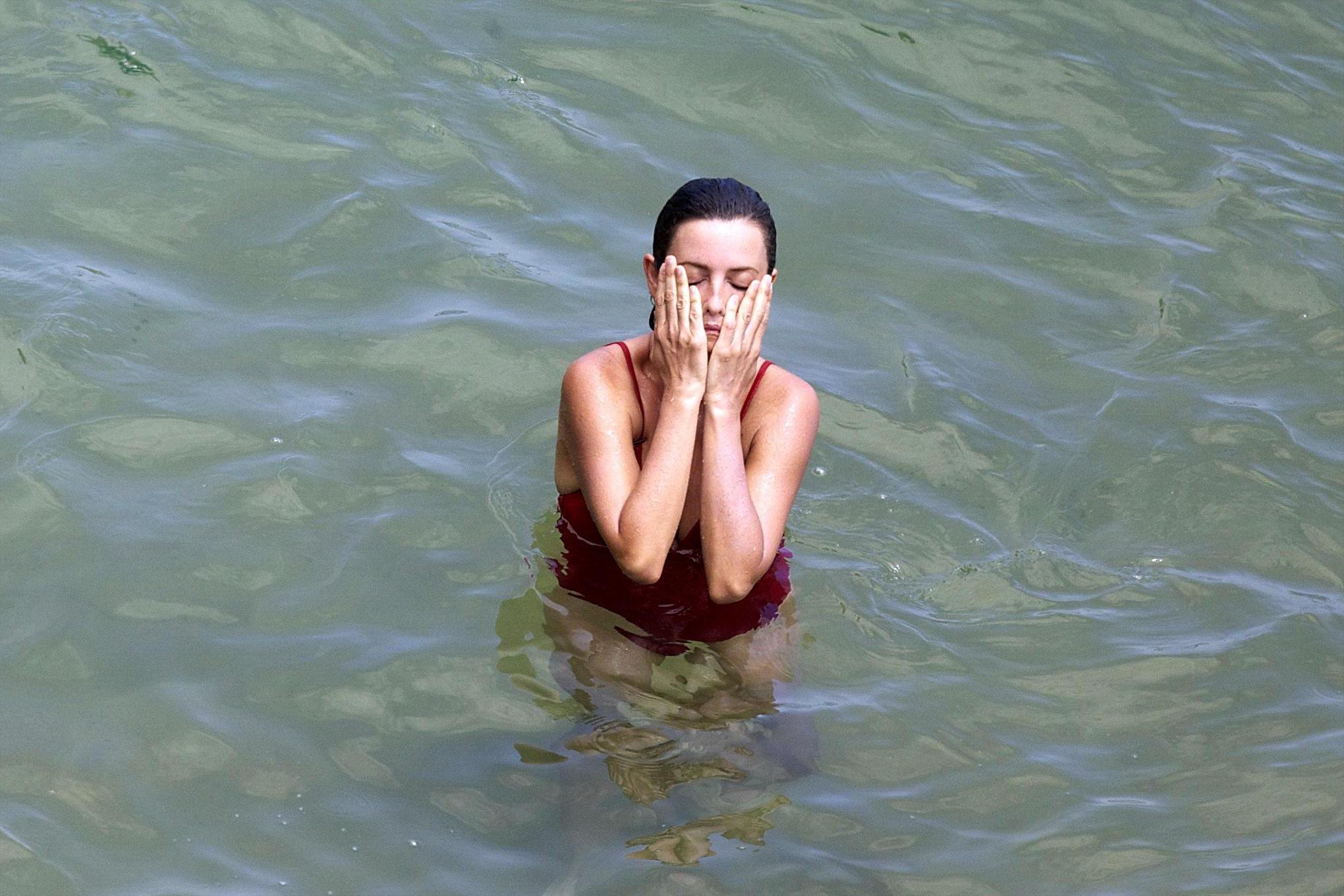 16P Penelope Cruz showing pokies on a beach wearing a sexy red swimsuit