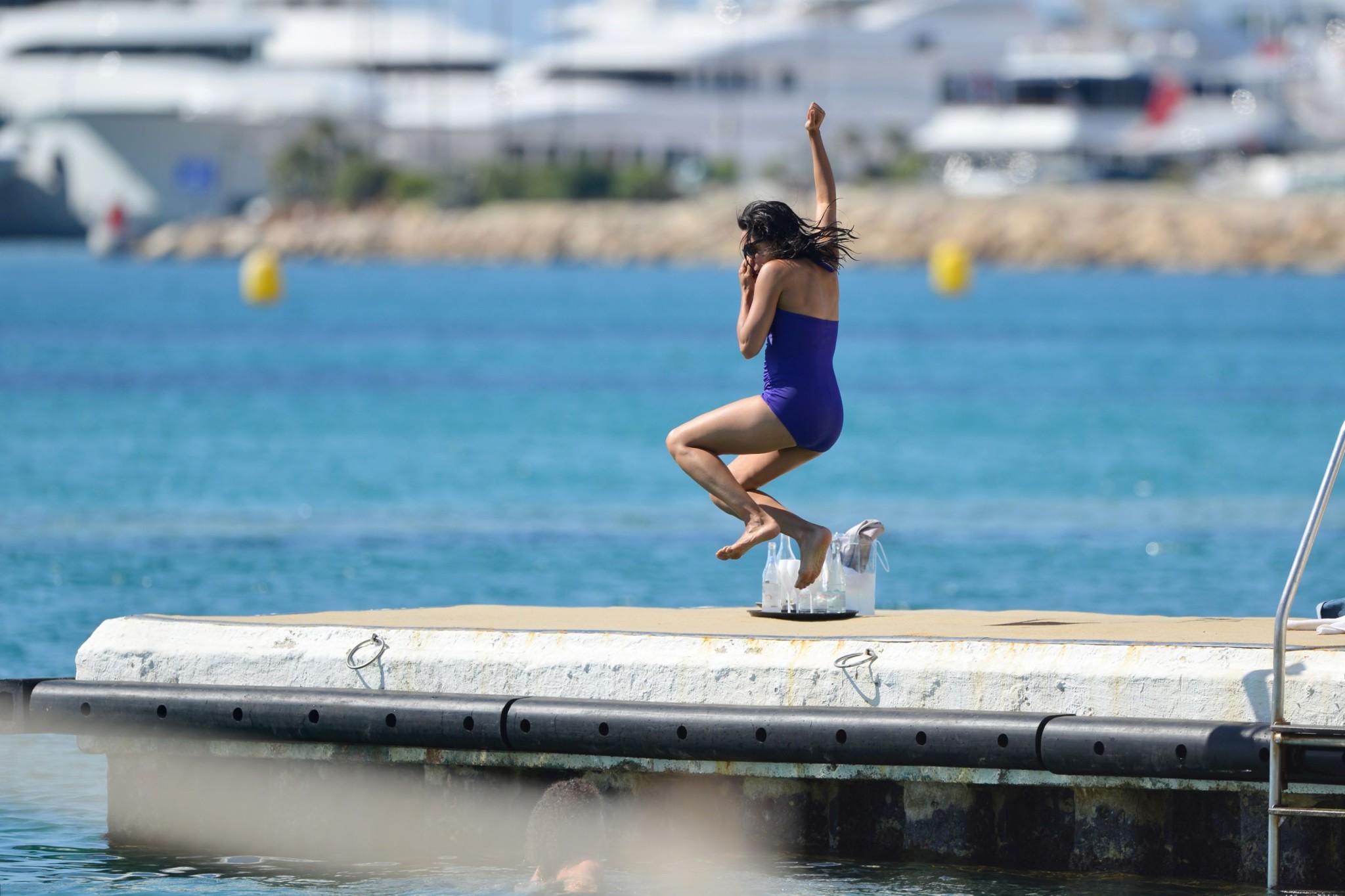 16P Rosario Dawson shows off her chubby body wearing a purple swimsuit  on the pier 