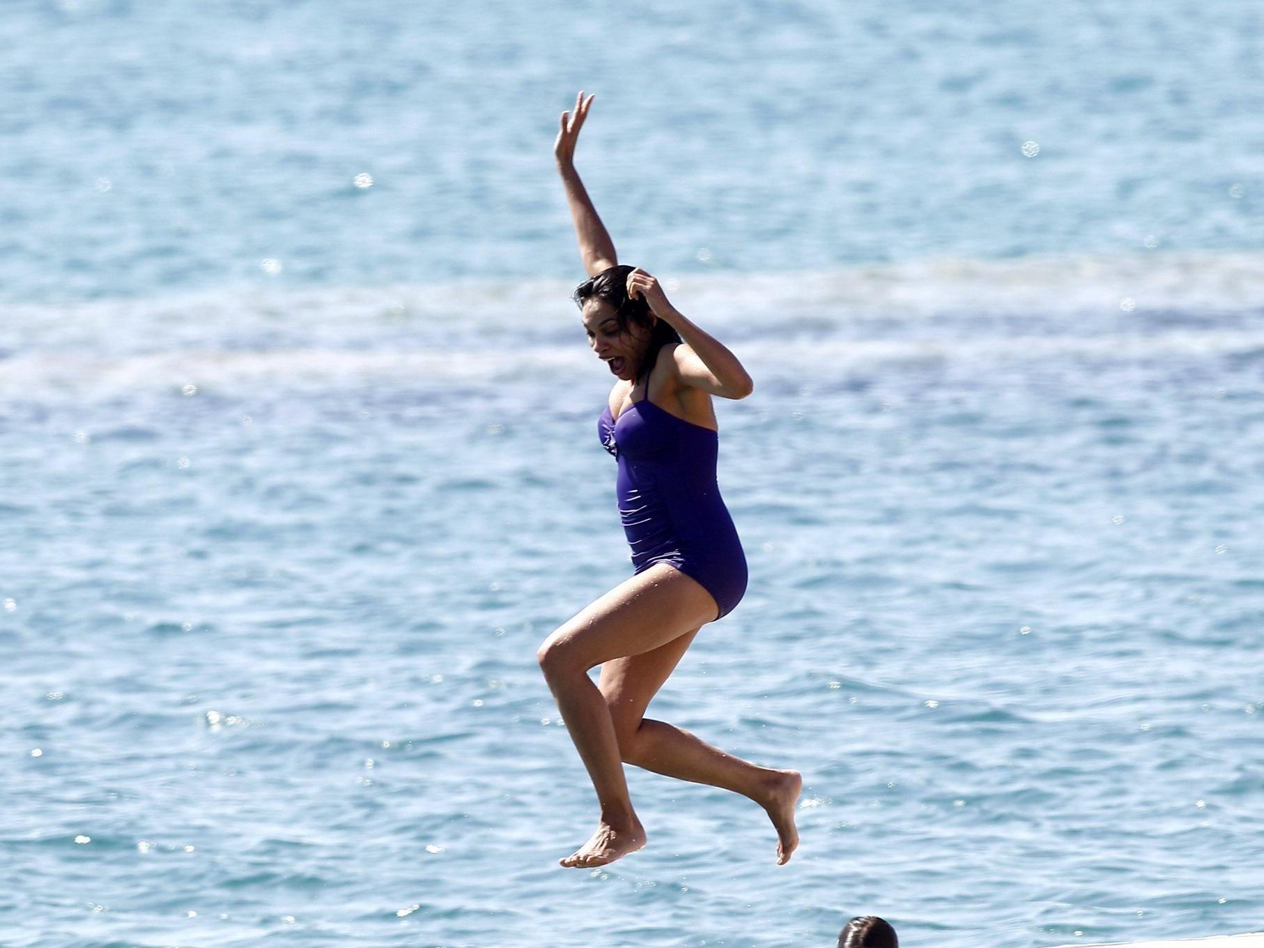 16P Rosario Dawson shows off her chubby body wearing a purple swimsuit  on the pier 