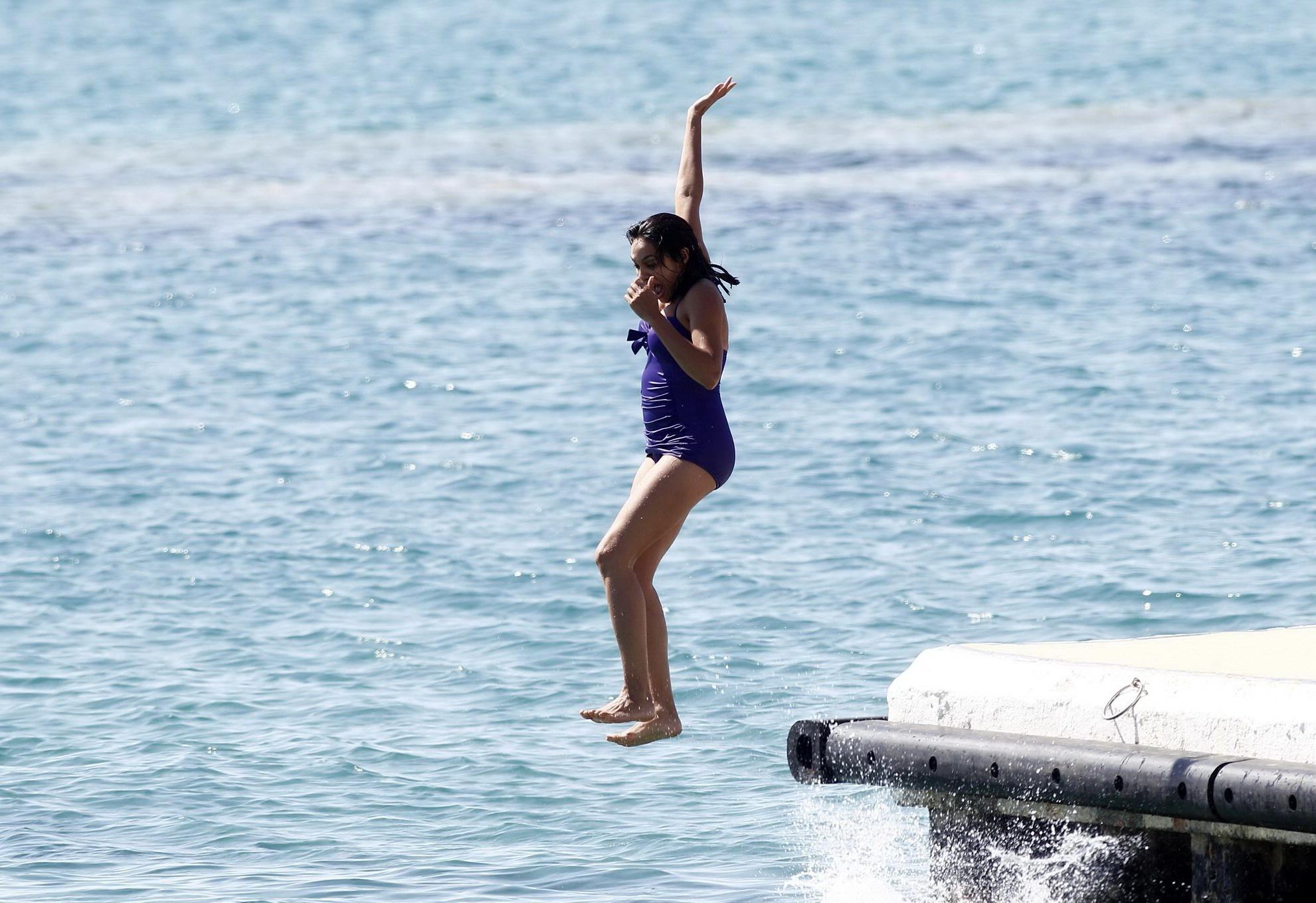 16P Rosario Dawson shows off her chubby body wearing a purple swimsuit  on the pier 