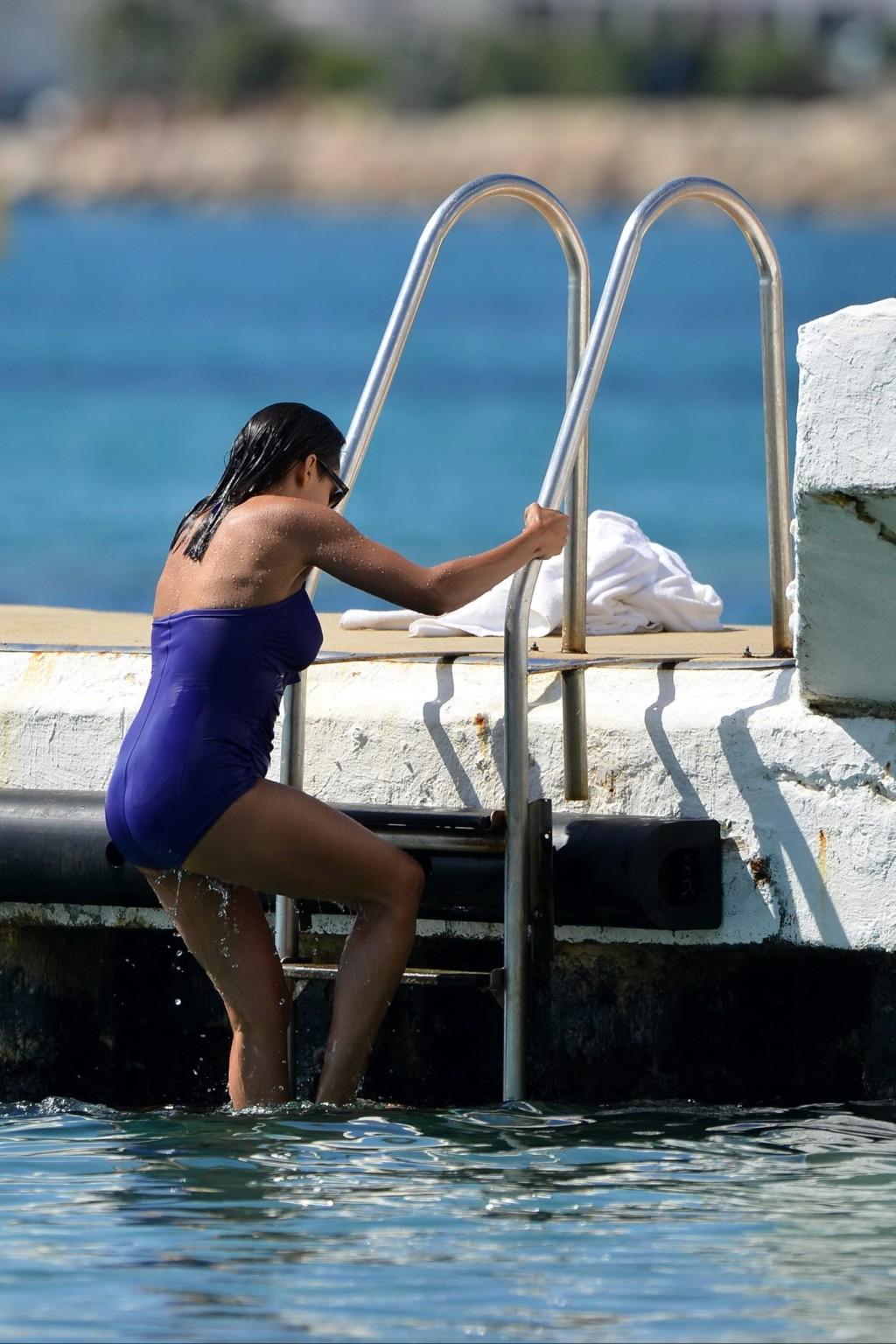 16P Rosario Dawson shows off her chubby body wearing a purple swimsuit  on the pier 