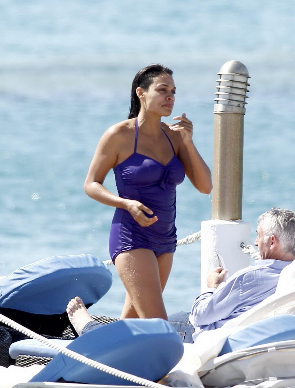 16P Busty babe Rosario Dawson have some problems with her purple swimsuit at the bea