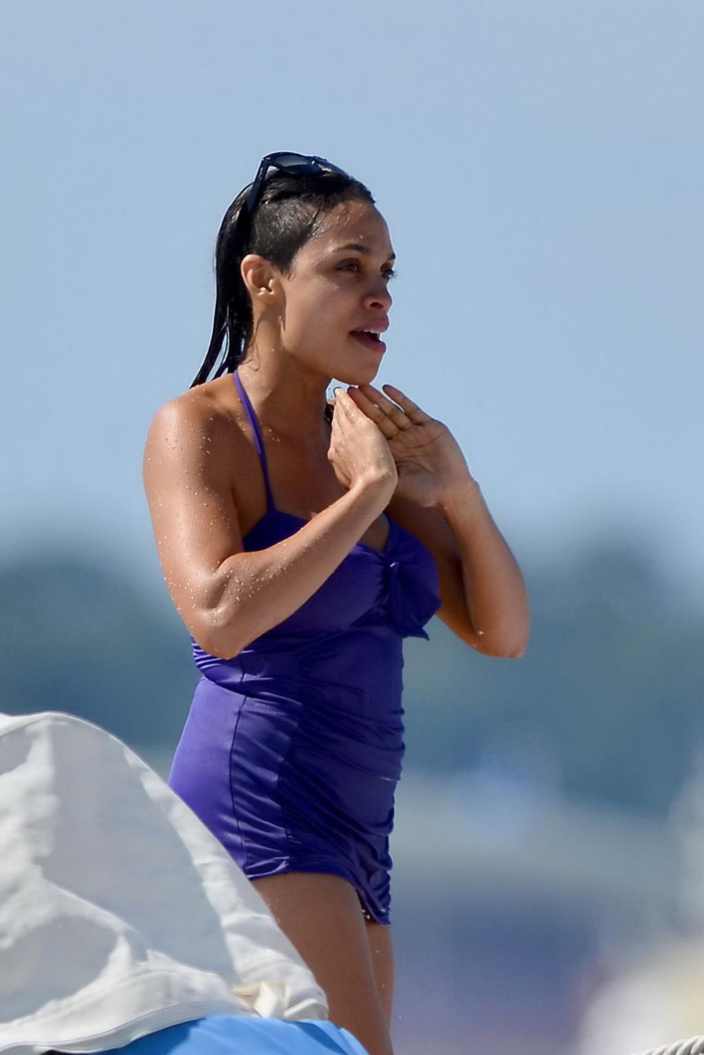 16P Busty babe Rosario Dawson have some problems with her purple swimsuit at the bea