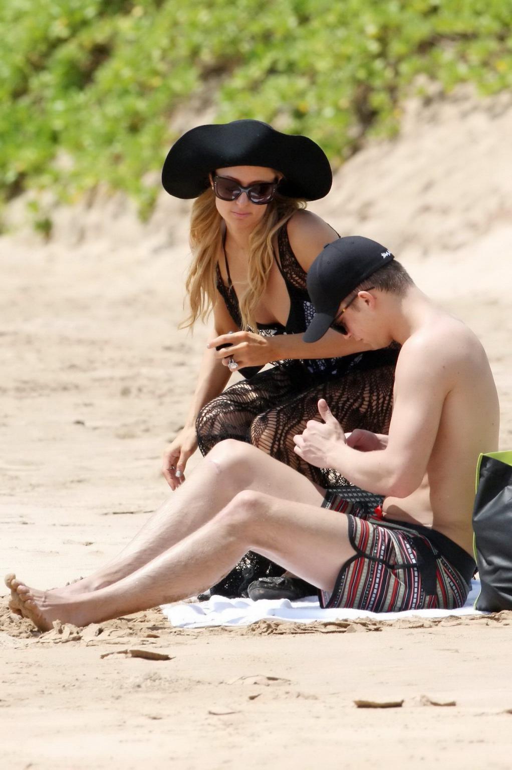 16P Paris Hilton wearing a swimsuit  a see through lace dress on a beach in Hawaii