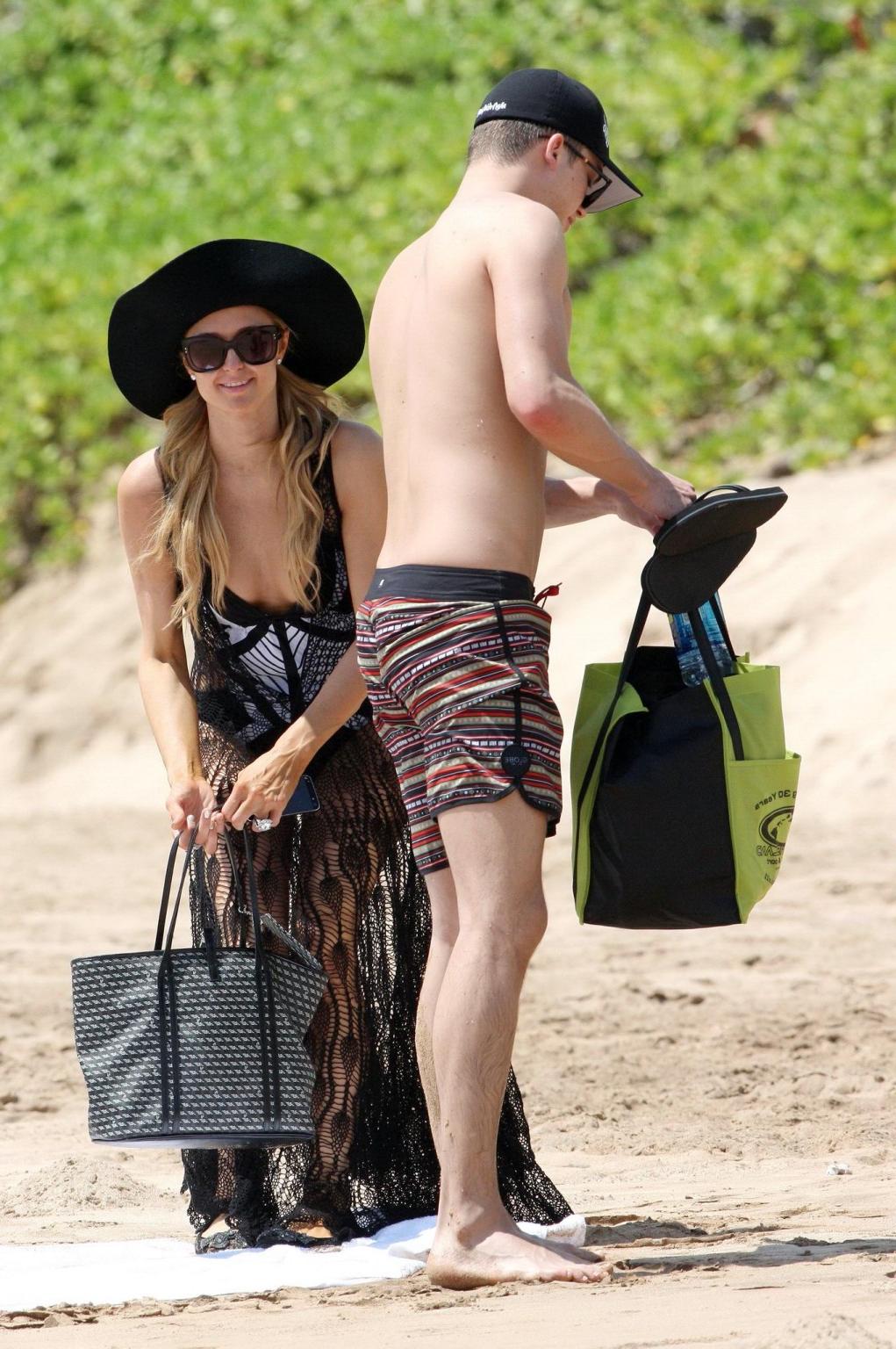 16P Paris Hilton wearing a swimsuit  a see through lace dress on a beach in Hawaii