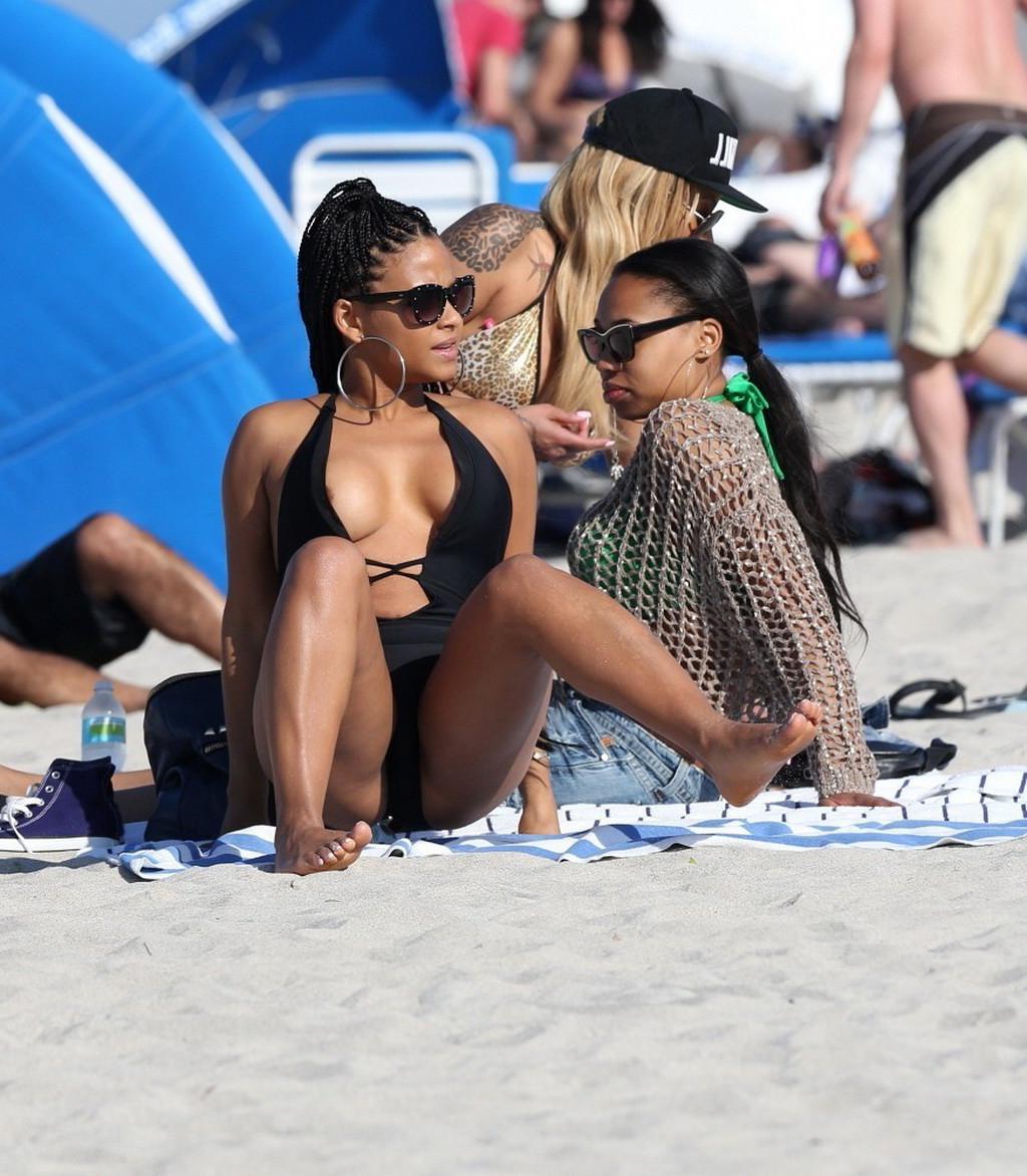 10P Christina Milian nipple slip wearing a skimpy black swimsuit in Miami Beach