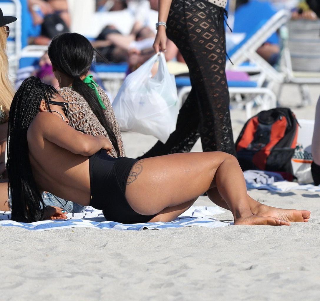 10P Christina Milian nipple slip wearing a skimpy black swimsuit in Miami Beach