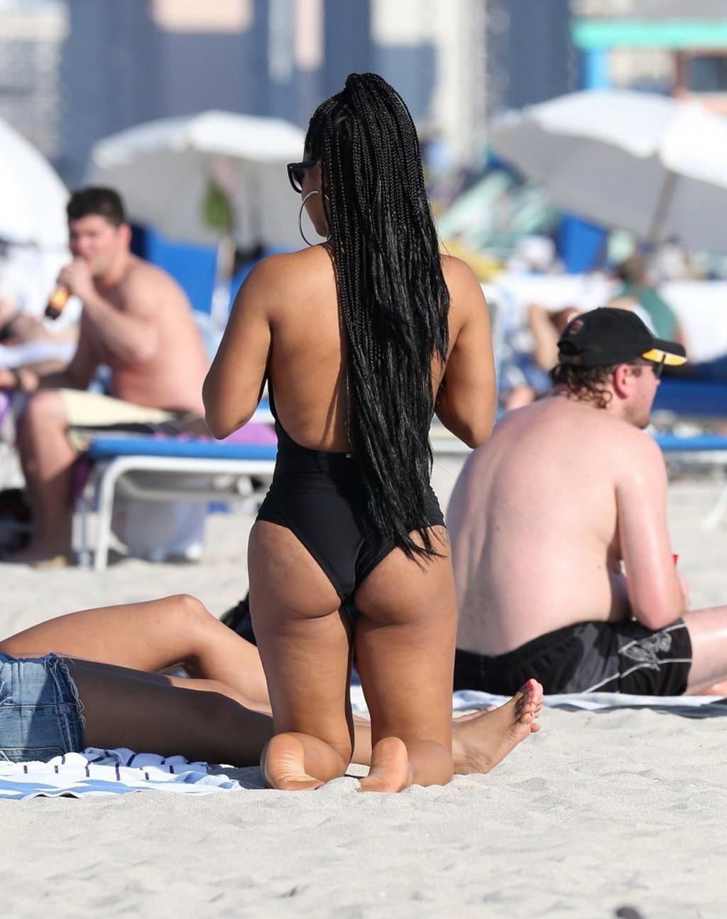 10P Christina Milian nipple slip wearing a skimpy black swimsuit in Miami Beach