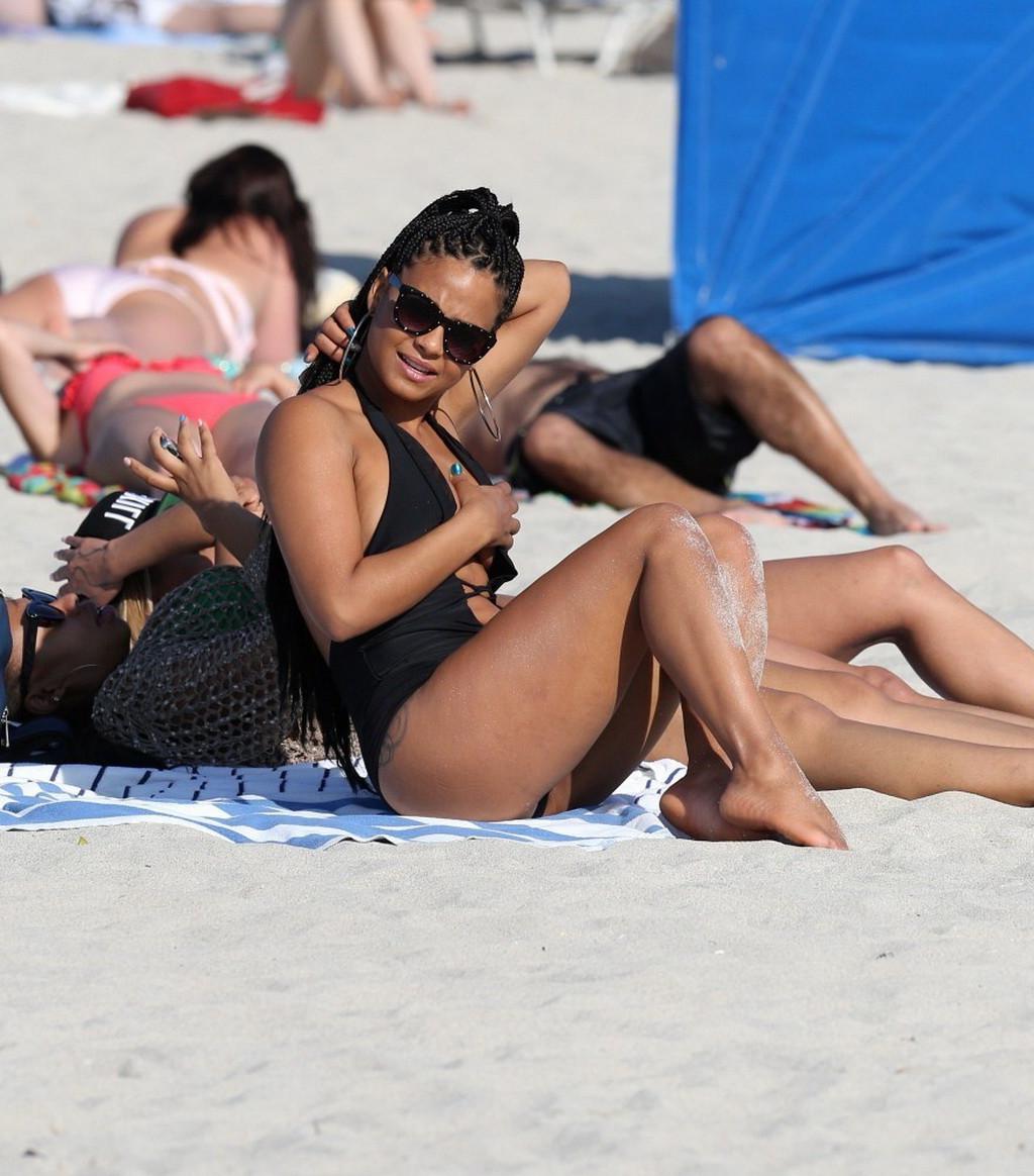 10P Christina Milian nipple slip wearing a skimpy black swimsuit in Miami Beach