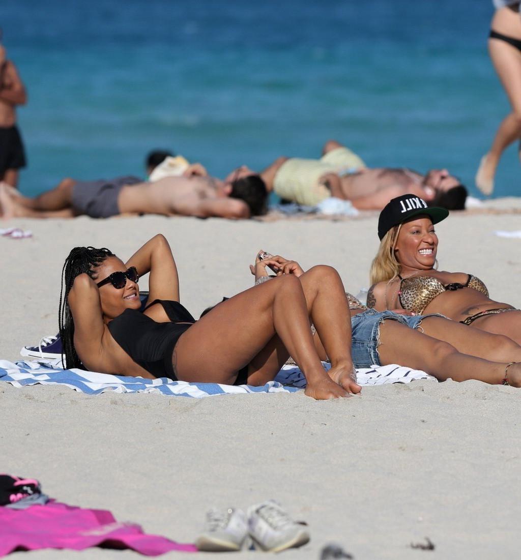 10P Christina Milian nipple slip wearing a skimpy black swimsuit in Miami Beach