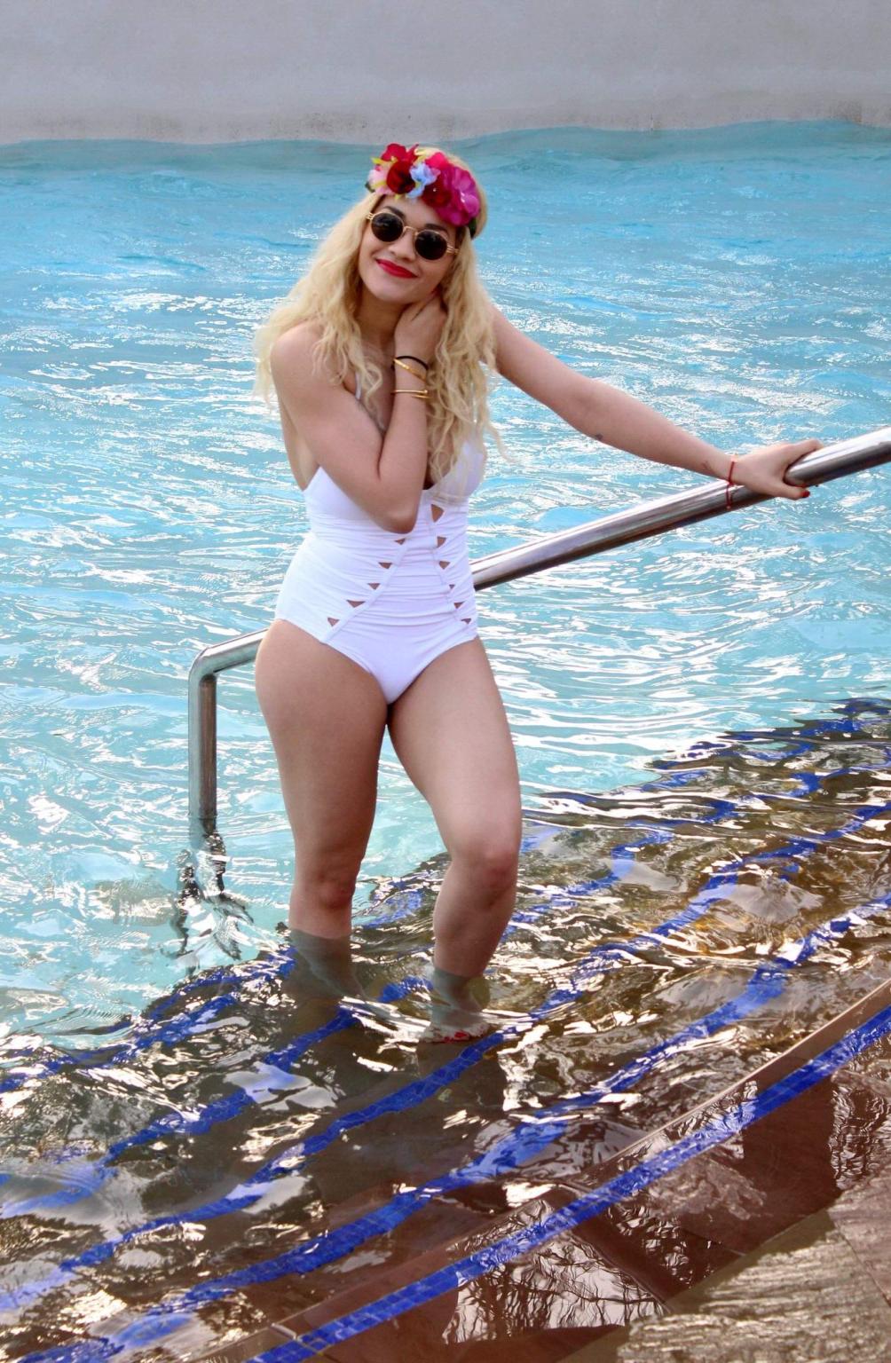 10P Rita Ora busty wearing a white slightly see through swimsuit at the pool in Duba