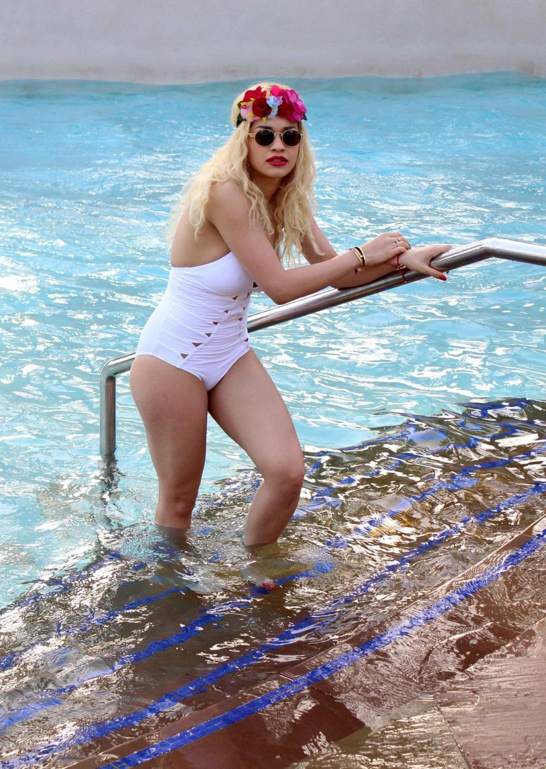 10P Rita Ora busty wearing a white slightly see through swimsuit at the pool in Duba