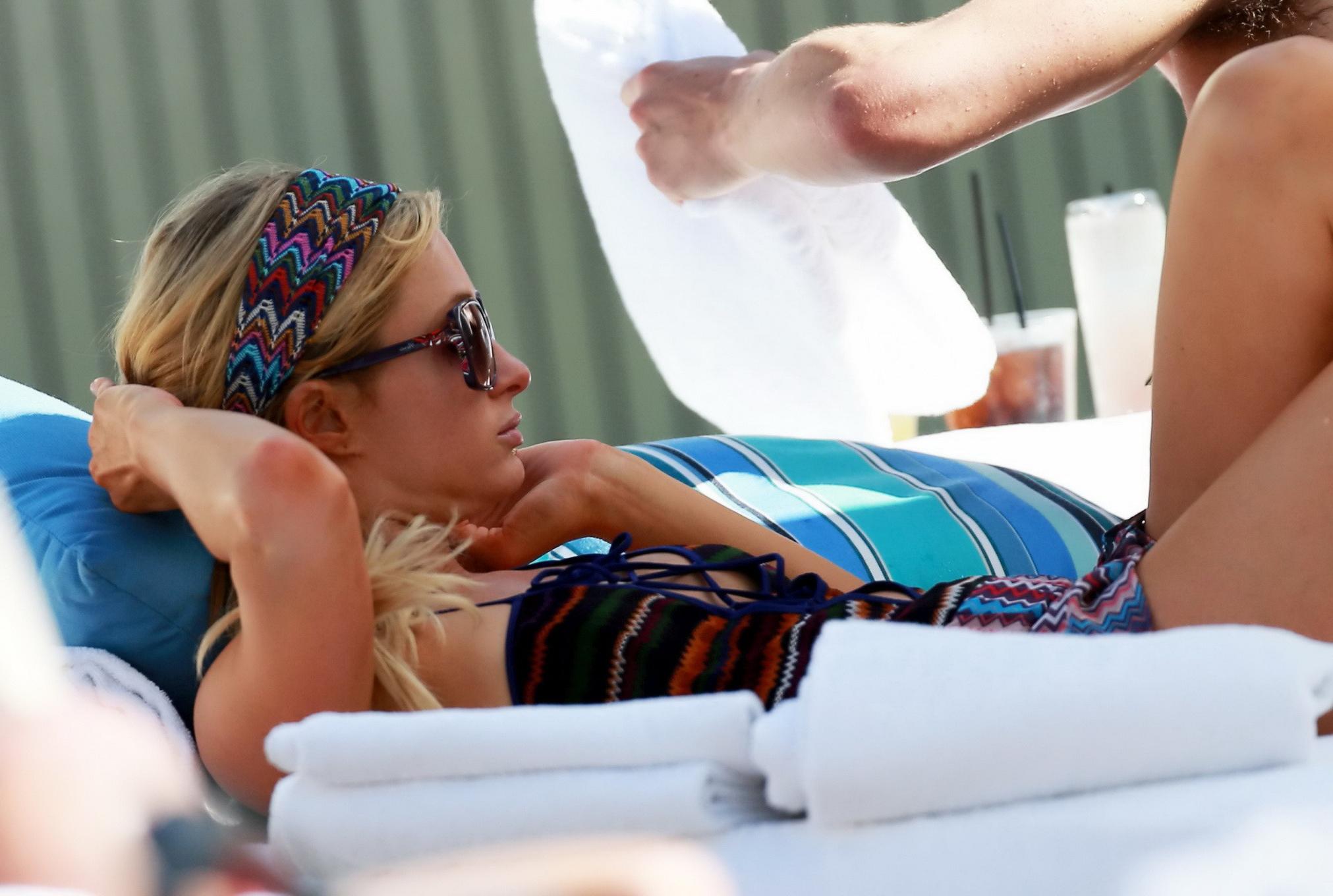 10P Paris Hilton showing off her hot body in skimpy multi colored swimsuit at a pool