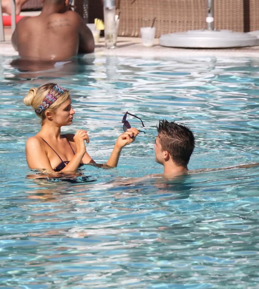 10P Paris Hilton showing off her hot body in skimpy multi colored swimsuit at a pool