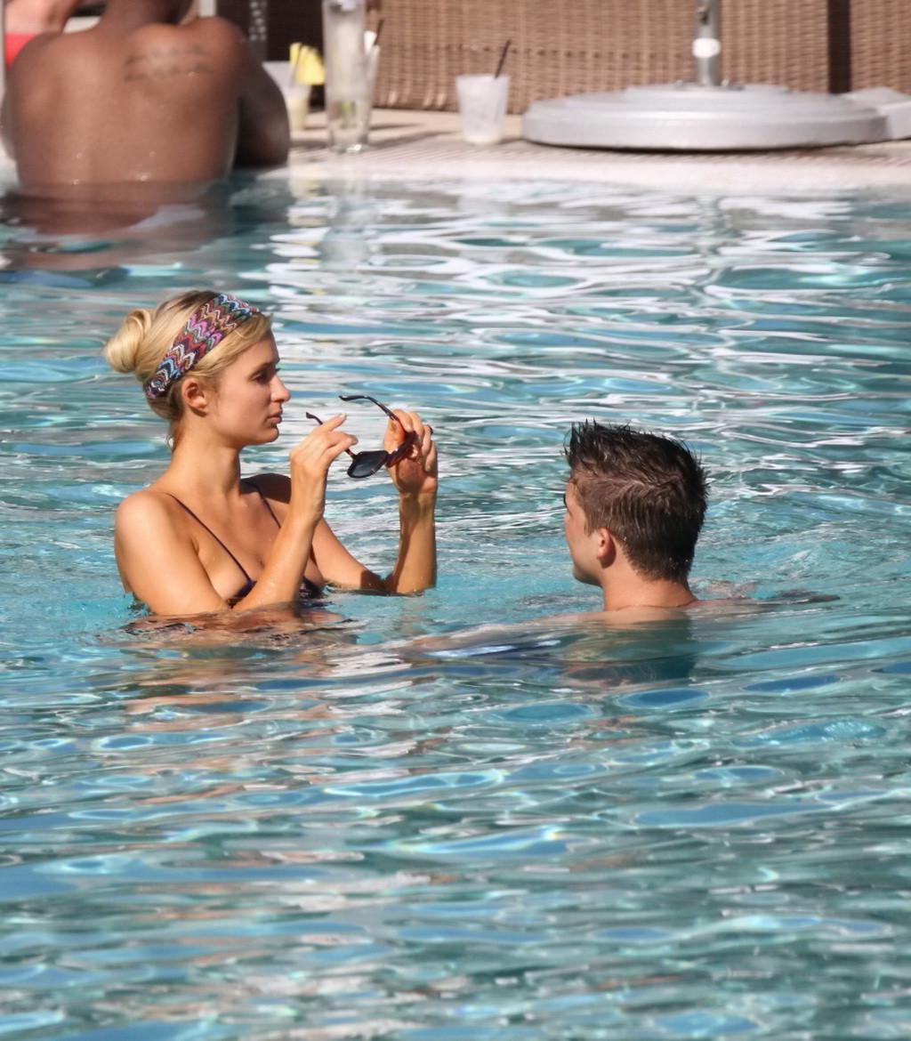 10P Paris Hilton showing off her hot body in skimpy multi colored swimsuit at a pool