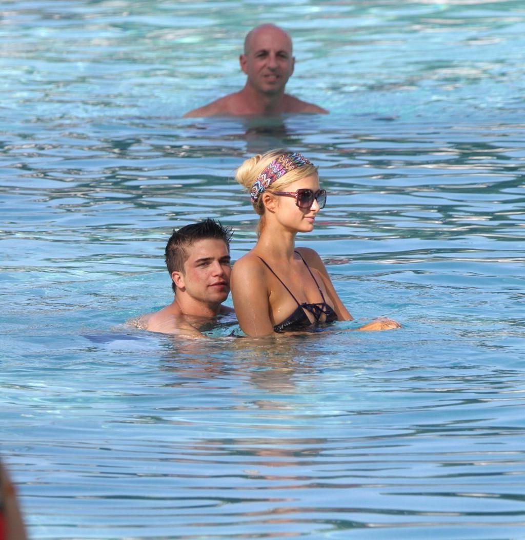 10P Paris Hilton showing off her hot body in skimpy multi colored swimsuit at a pool