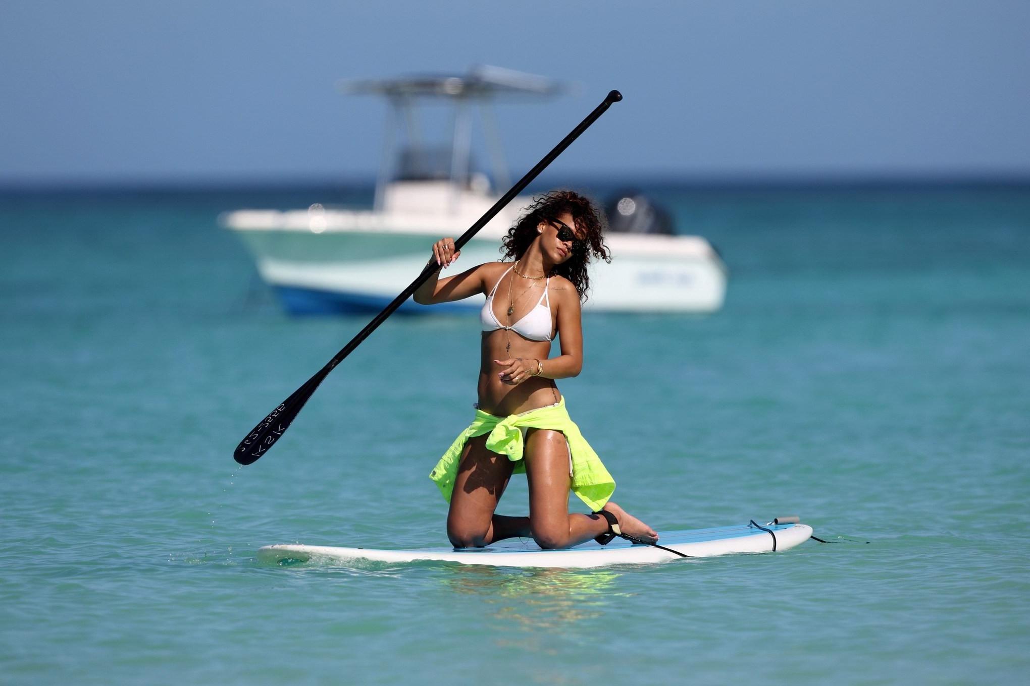 16P Rihanna paddle surfing in white bikini on a Hawaiian beach