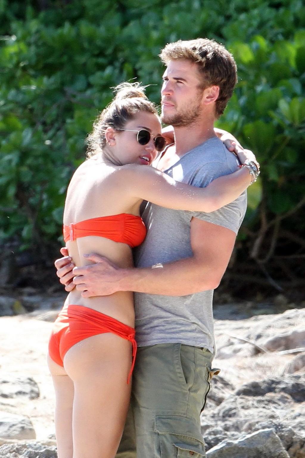 16P Miley Cyrus wearing sexy orange bikini on a Hawaiian beach