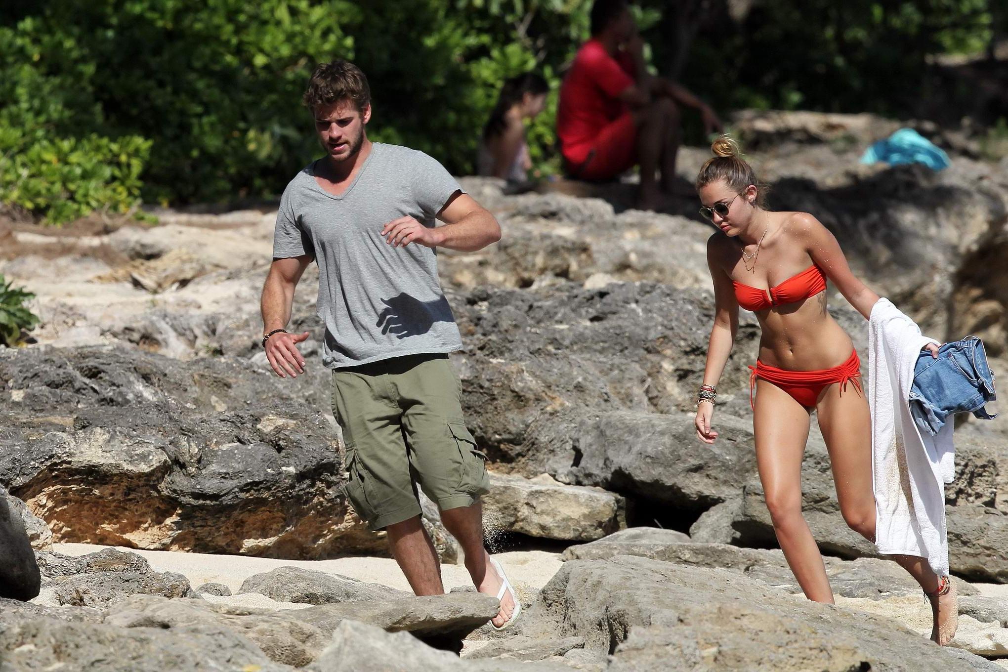 16P Miley Cyrus wearing sexy orange bikini on a Hawaiian beach