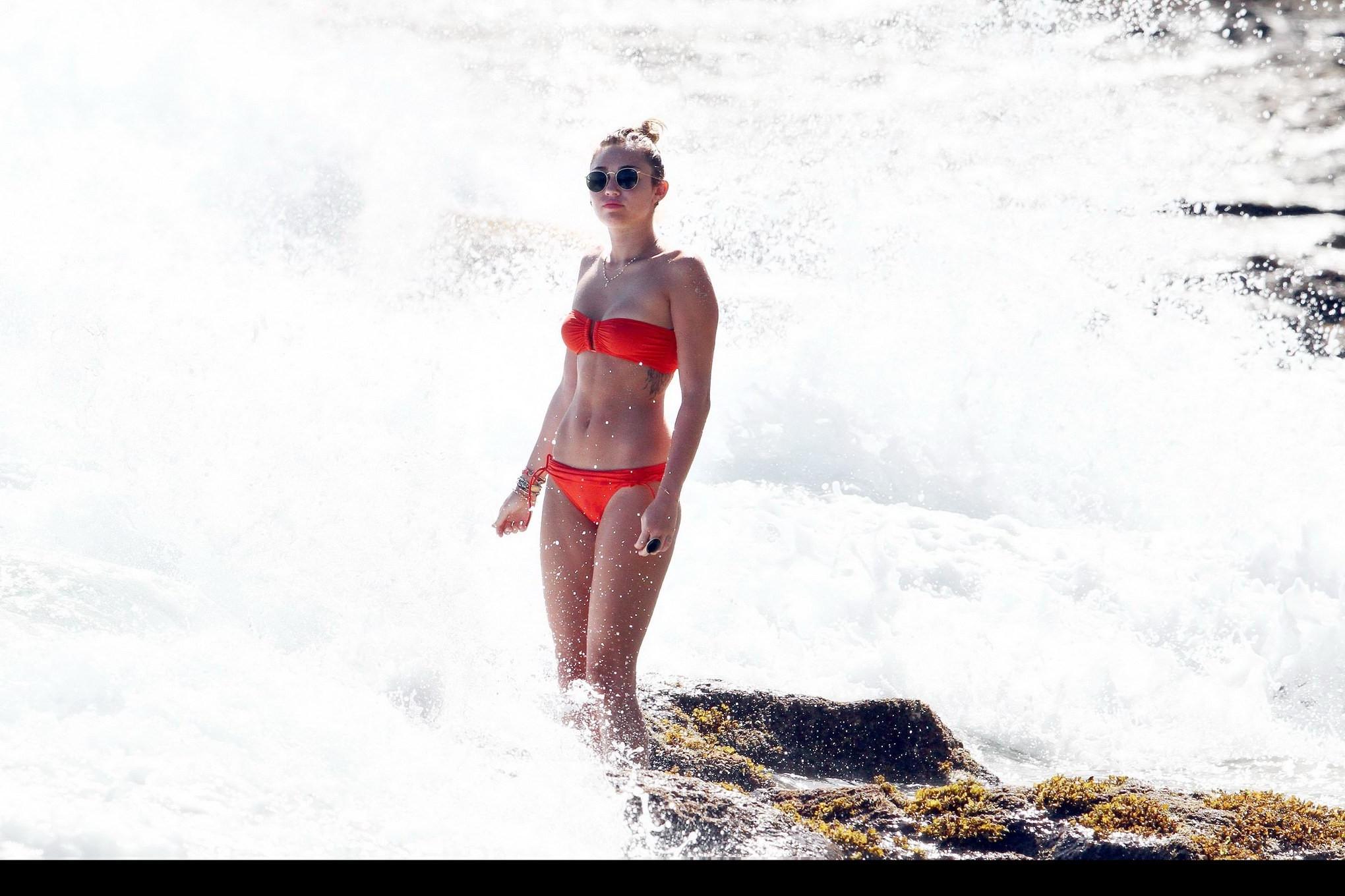 16P Miley Cyrus wearing sexy orange bikini on a Hawaiian beach
