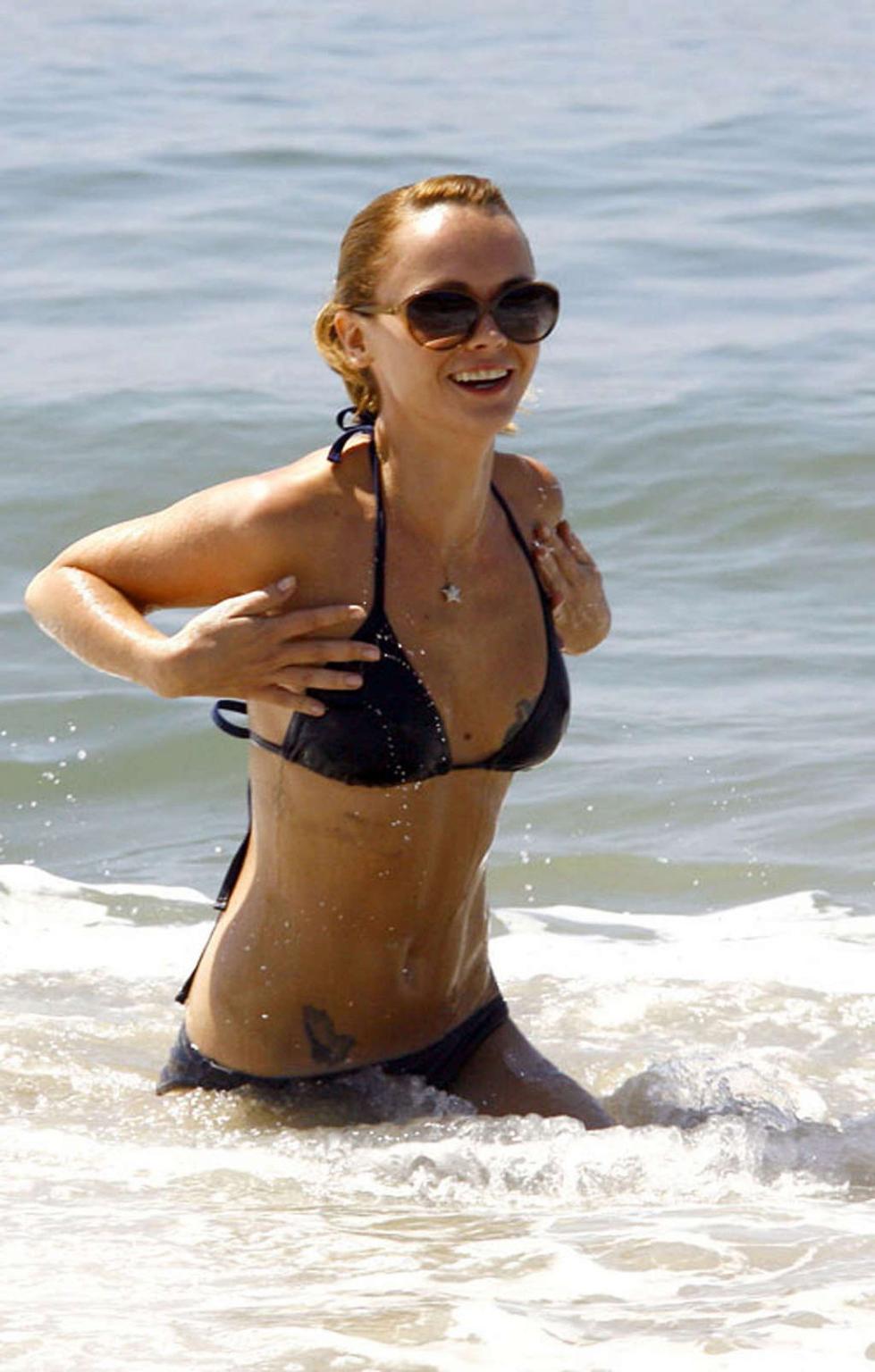 16P Christina Ricci looking very drunk in bikini with a beer in a hand