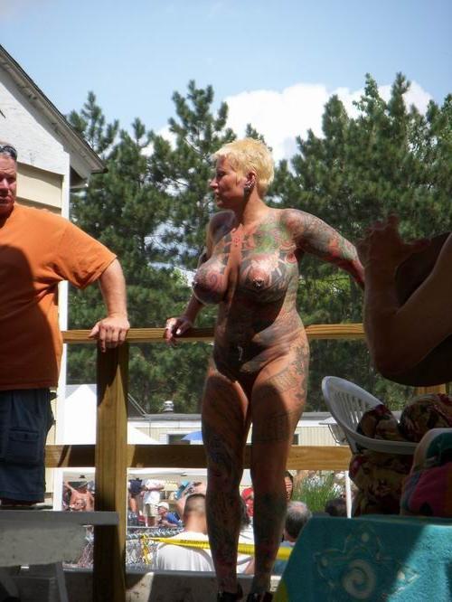 15P Busty tattooed milf posing naked outdoors