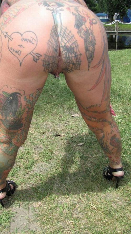 15P Busty tattooed milf posing naked outdoors