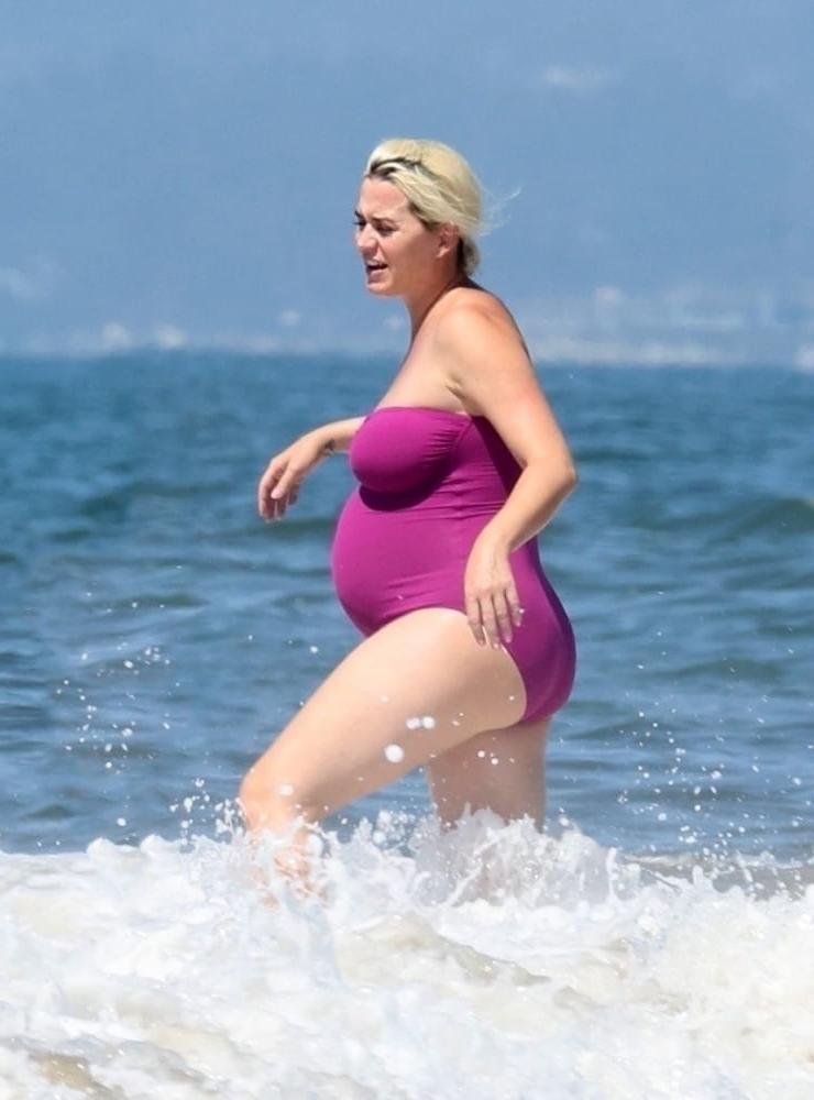 19P Pregnant Katy Perry in a purple swimsuit.