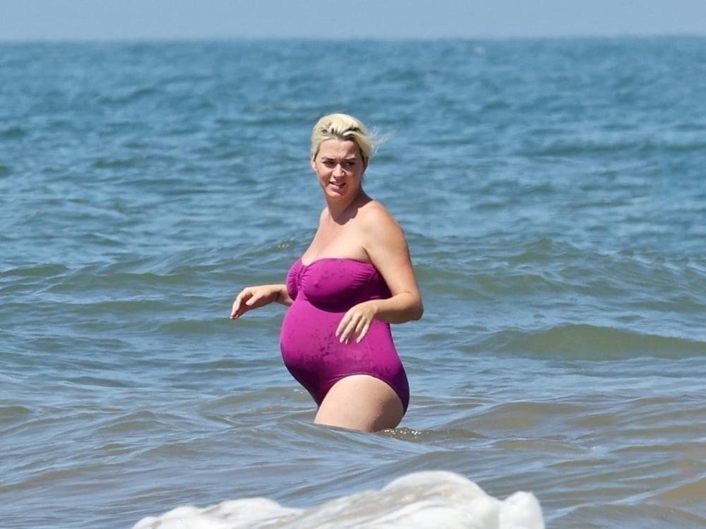 19P Pregnant Katy Perry in a purple swimsuit.