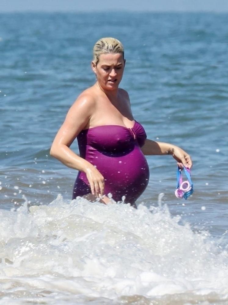 19P Pregnant Katy Perry in a purple swimsuit.