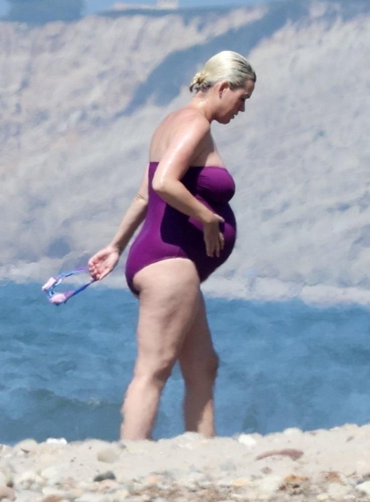 19P Pregnant Katy Perry in a purple swimsuit.