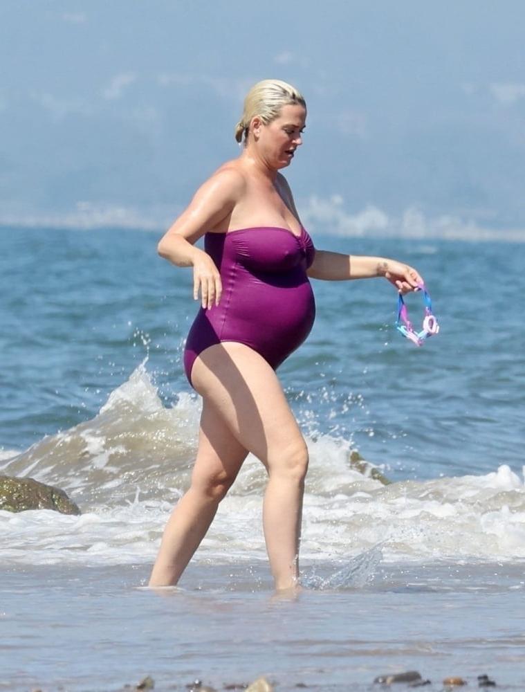 19P Pregnant Katy Perry in a purple swimsuit.