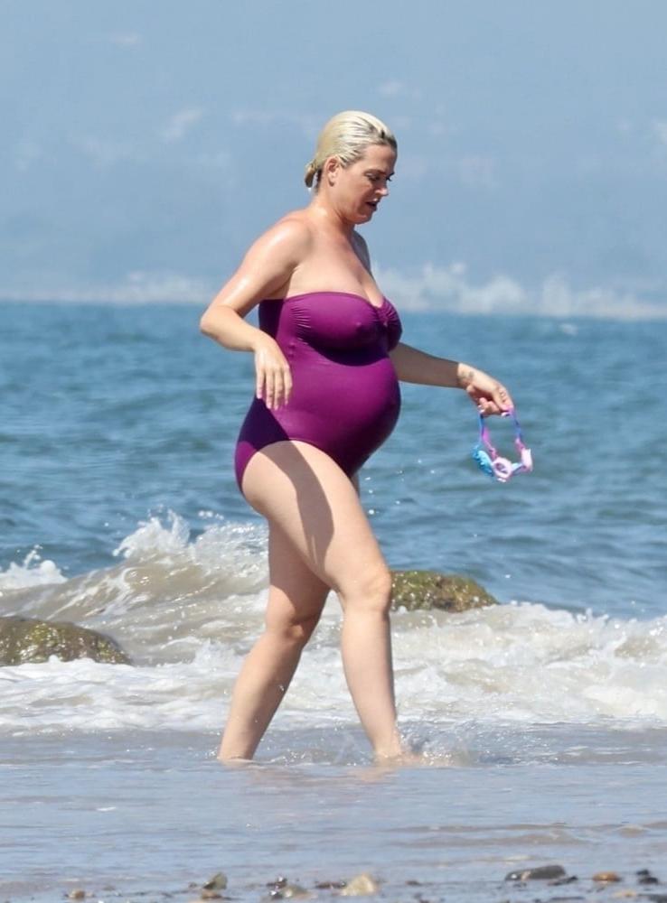 19P Pregnant Katy Perry in a purple swimsuit.