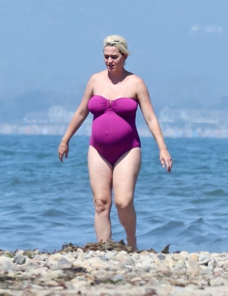 19P Pregnant Katy Perry in a purple swimsuit.