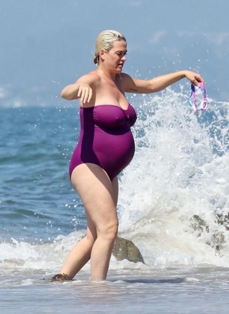 19P Pregnant Katy Perry in a purple swimsuit.