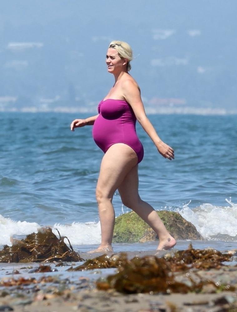 19P Pregnant Katy Perry in a purple swimsuit.