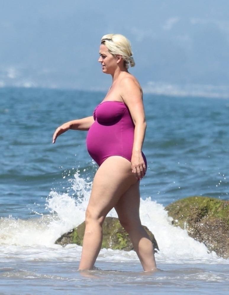 19P Pregnant Katy Perry in a purple swimsuit.