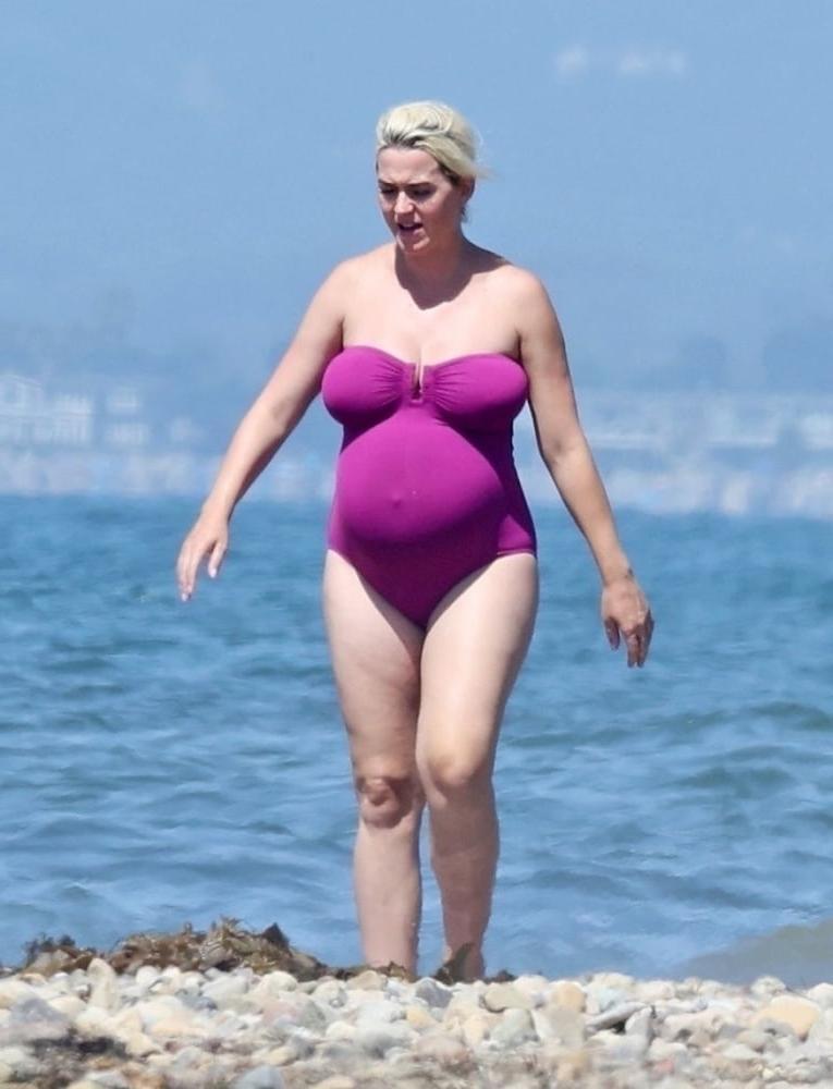 19P Pregnant Katy Perry in a purple swimsuit.