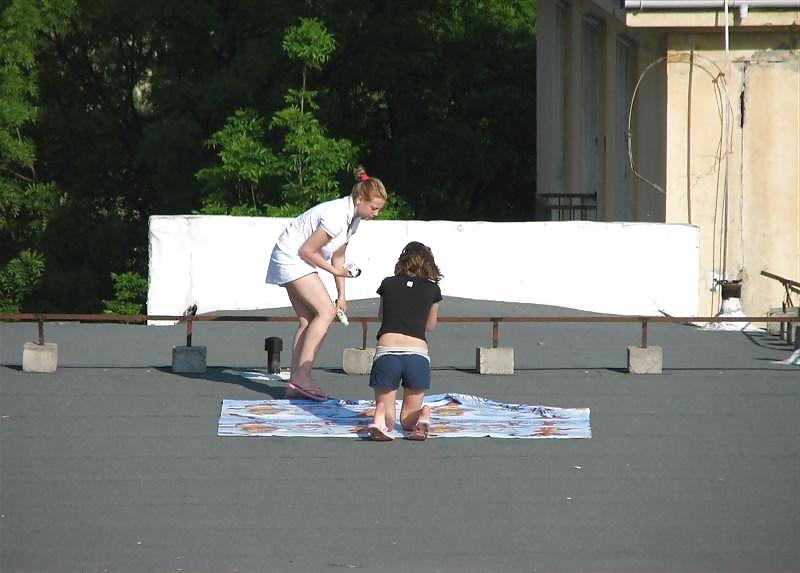 12P Three vouyered girls undressing and sunbathing in the roof.