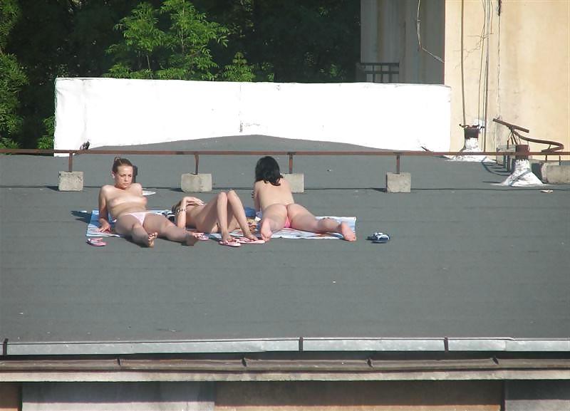 12P Three vouyered girls undressing and sunbathing in the roof.