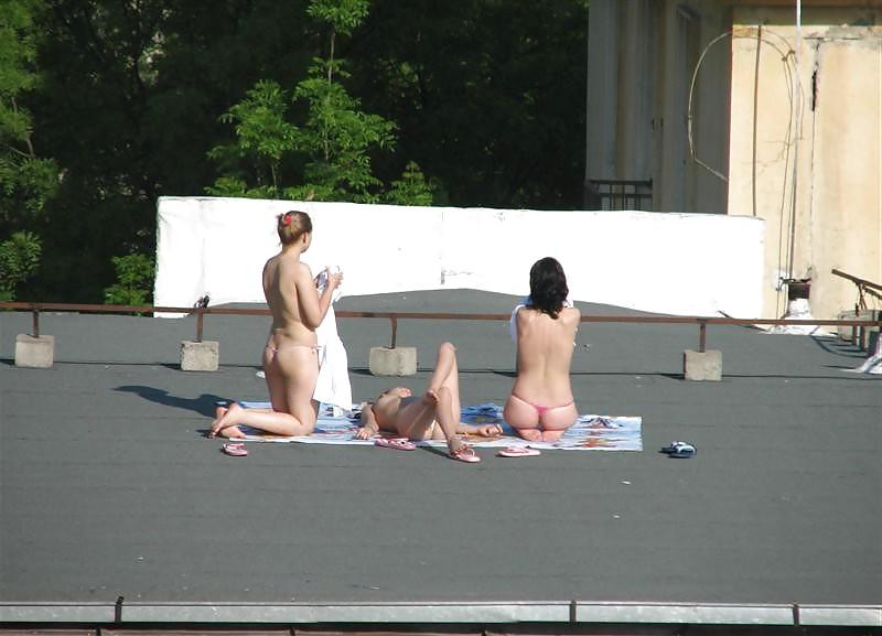 12P Three vouyered girls undressing and sunbathing in the roof.
