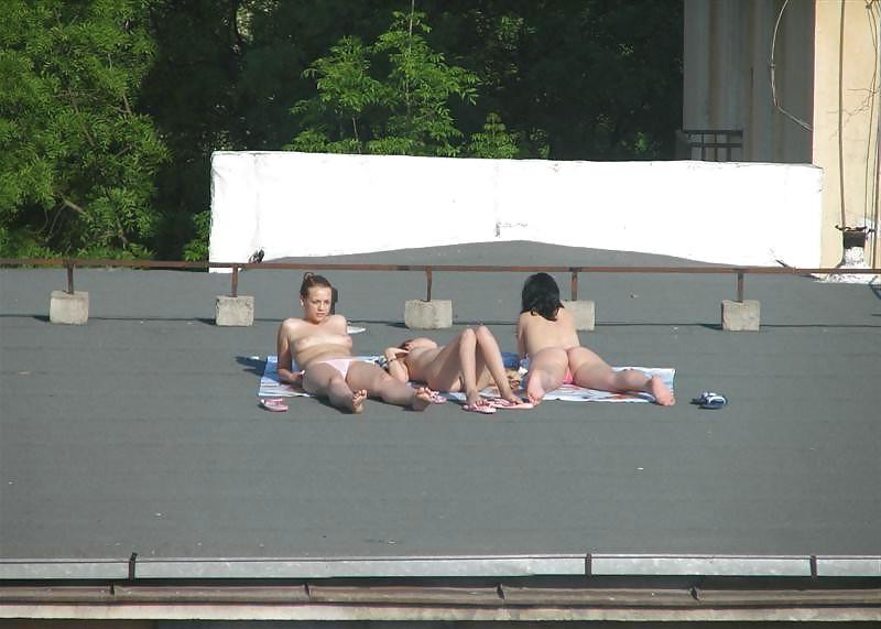 12P Three vouyered girls undressing and sunbathing in the roof.