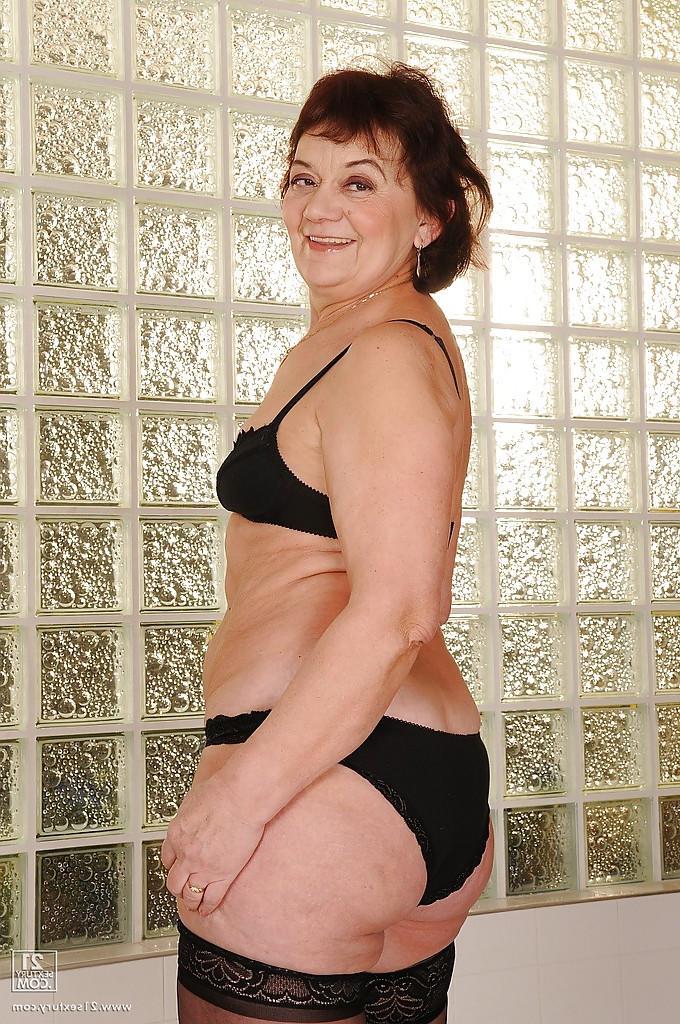 16P Slutty granny in stockings strips to her naked body and hairy pussy