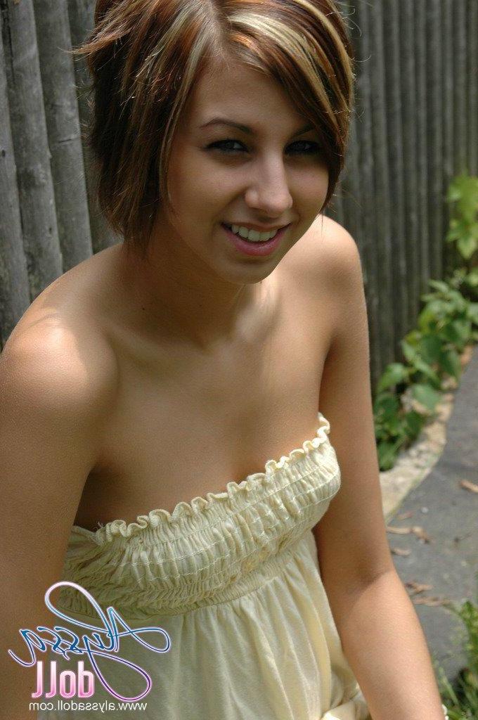 15P Alyssa poses by the fence in a yellow top and denim skirt