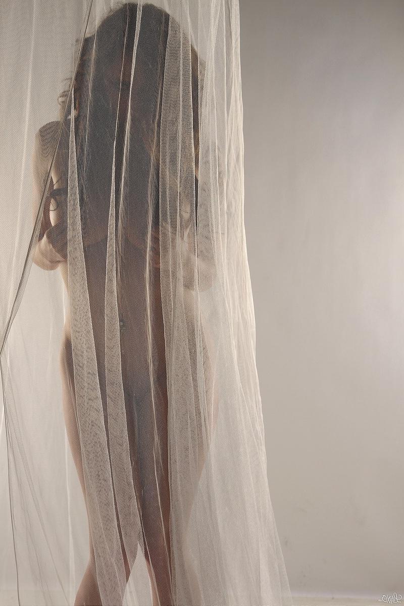 15P Lily poses behind a sheer curtain and teases