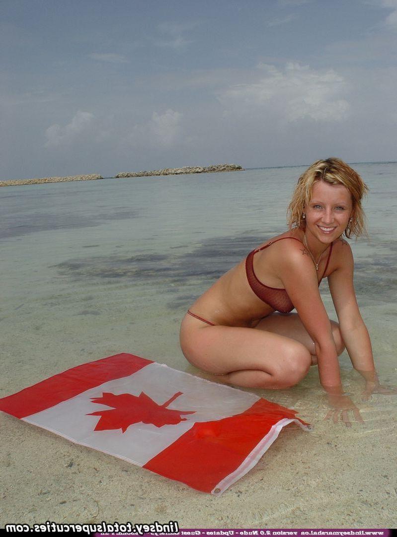 20P Pictures of teen chick Lindsey Marshal wrapped up in a Canadian flag on the beac