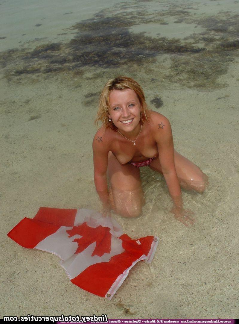 20P Pictures of teen chick Lindsey Marshal wrapped up in a Canadian flag on the beac