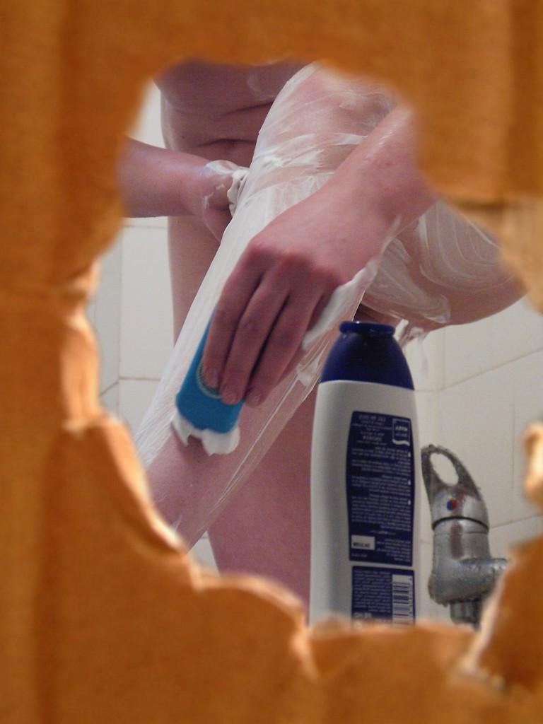 16P Voyeur peeks at brunette chick shaving her legs in the shower