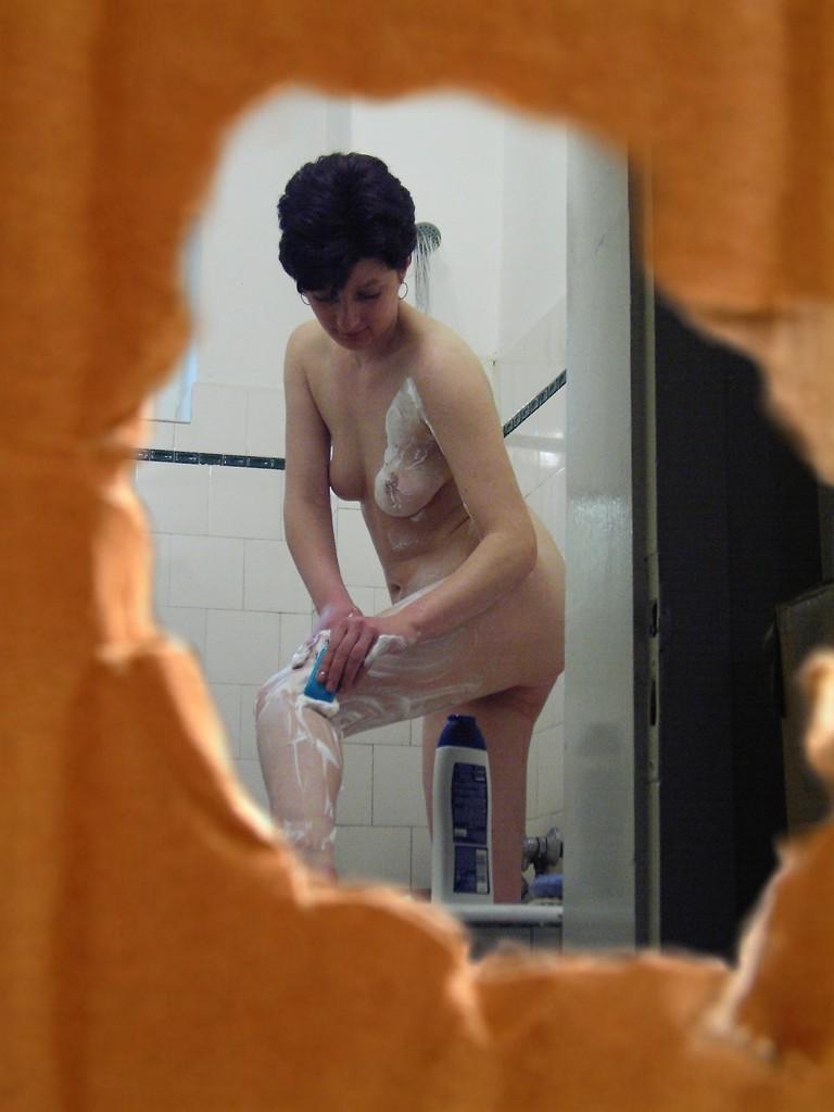 16P Voyeur peeks at brunette chick shaving her legs in the shower