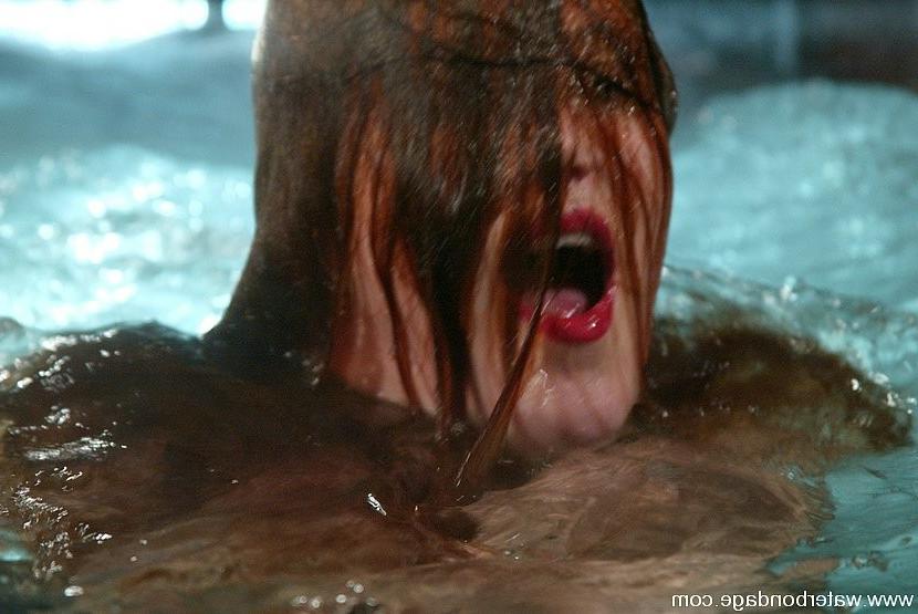 15P Redhead stockings babe in rope bondage is put in water tank